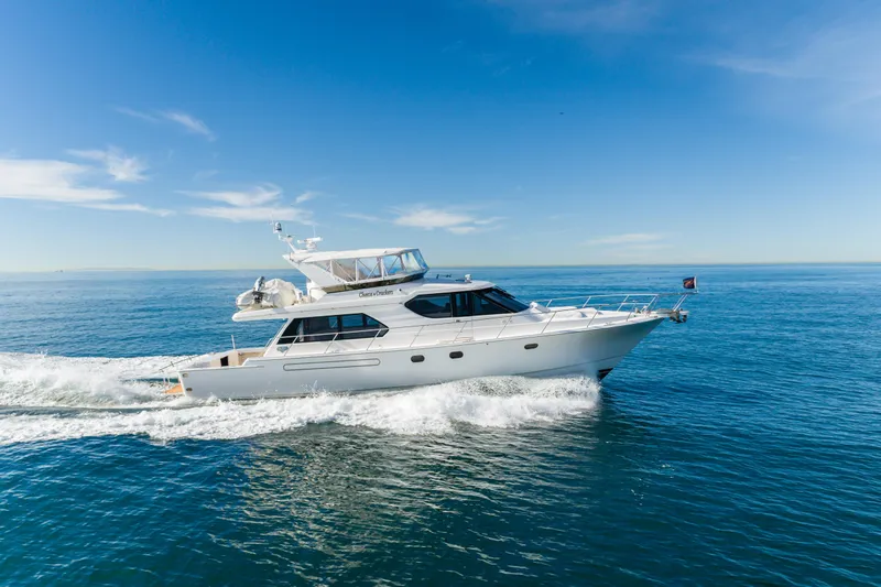 Slide: The Image of Luxury 2006 West Bay 64 yacht cruising on open sea under clear blue sky. - 11