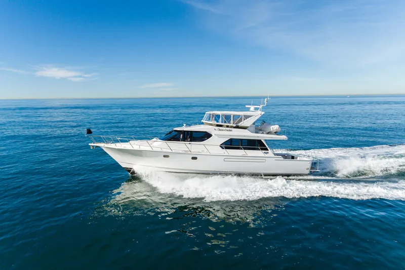 Slide: The Image of 2006 West Bay 64 yacht cruising on open sea under clear blue sky. - 13