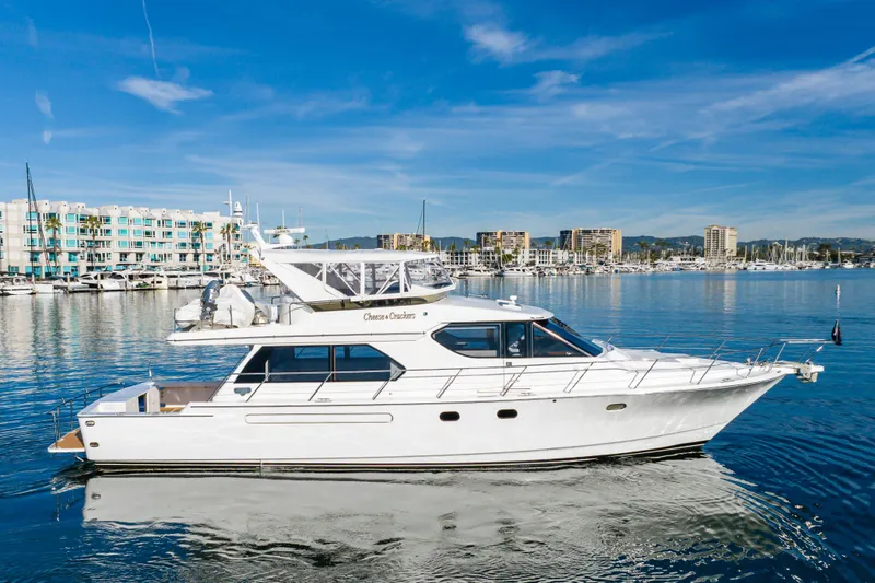 Slide: The Image of 2006 West Bay 64 yacht cruising in a marina with cityscape background. - 2