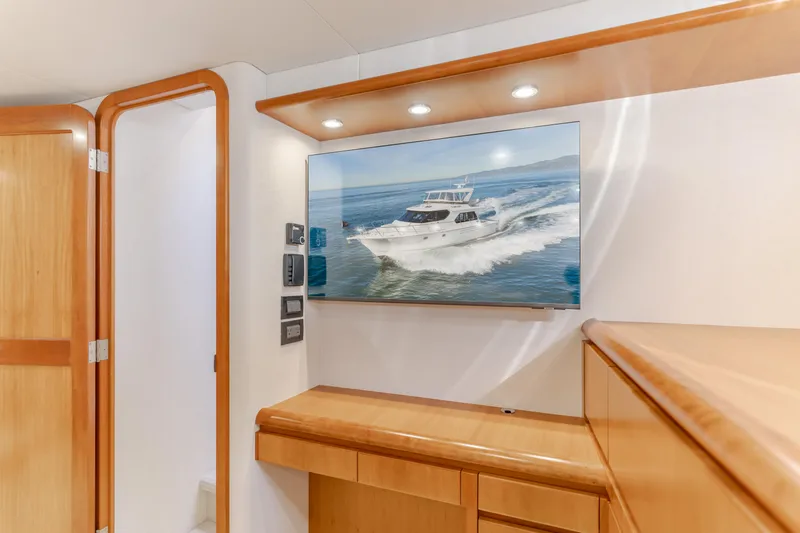 Slide: The Image of Interior of 2006 West Bay 64 yacht with modern wood finish and wall-mounted TV. - 22