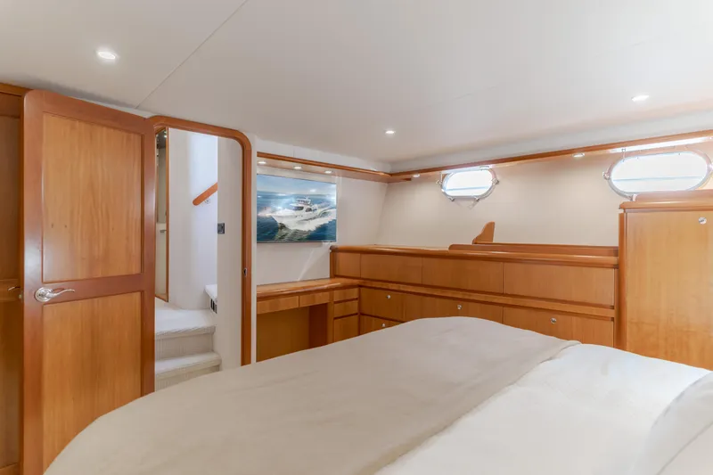Slide: The Image of Luxurious 2006 West Bay 64 yacht bedroom with wood accents and natural light. - 23
