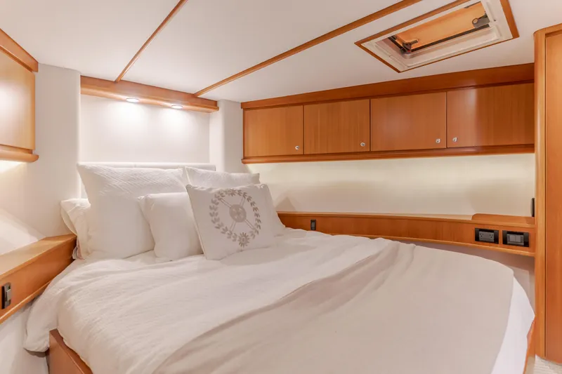Slide: The Image of Luxurious bedroom interior of 2006 West Bay 64 yacht with wood accents and cozy bedding. - 28