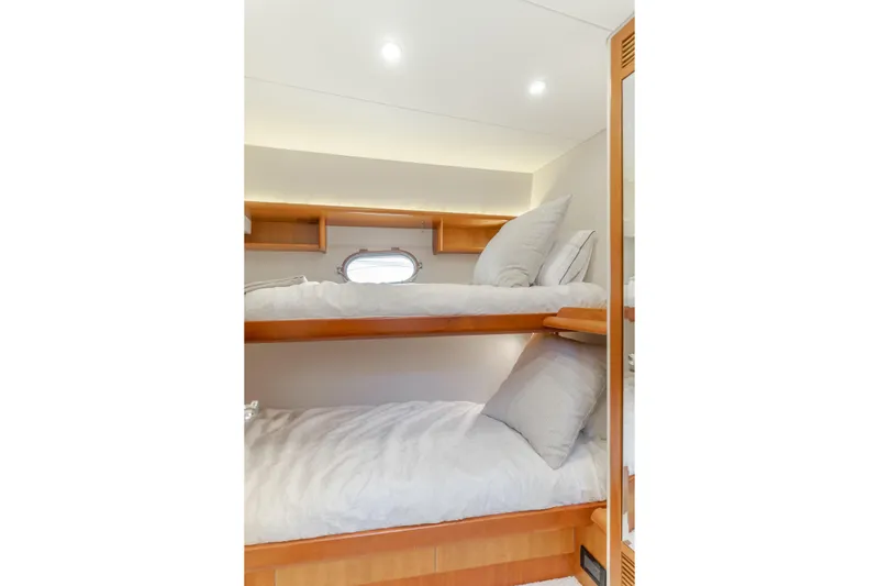Slide: The Image of Bunk beds in 2006 West Bay 64 yacht cabin with cozy bedding and wooden accents. - 30