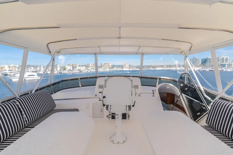 Slide: The Image of Luxurious 2006 West Bay 64 yacht interior with striped seating and panoramic marina view. - 35