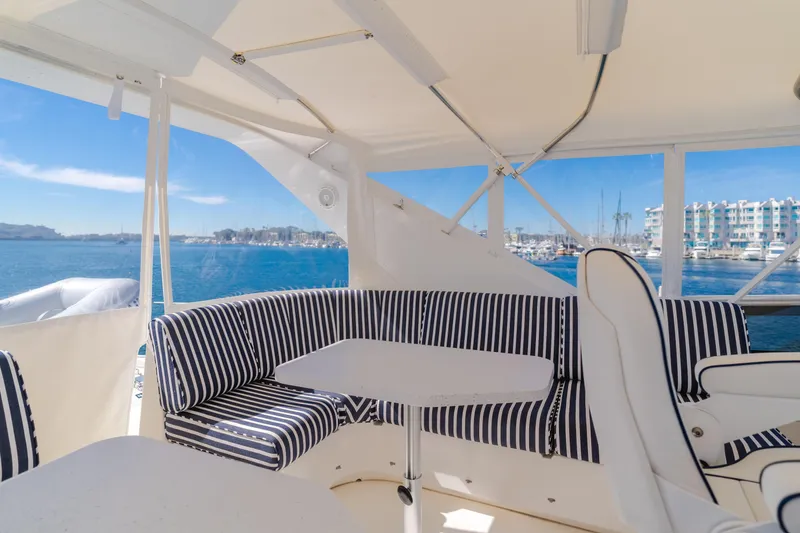 Slide: The Image of Luxurious 2006 West Bay 64 yacht interior with striped seating, overlooking marina and ocean views. - 36