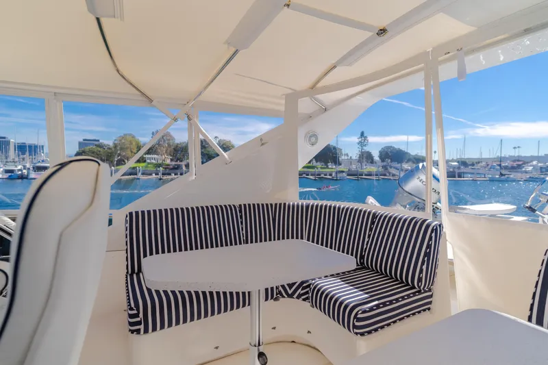 Slide: The Image of Luxurious 2006 West Bay 64 yacht interior with striped seating, overlooking marina. - 37