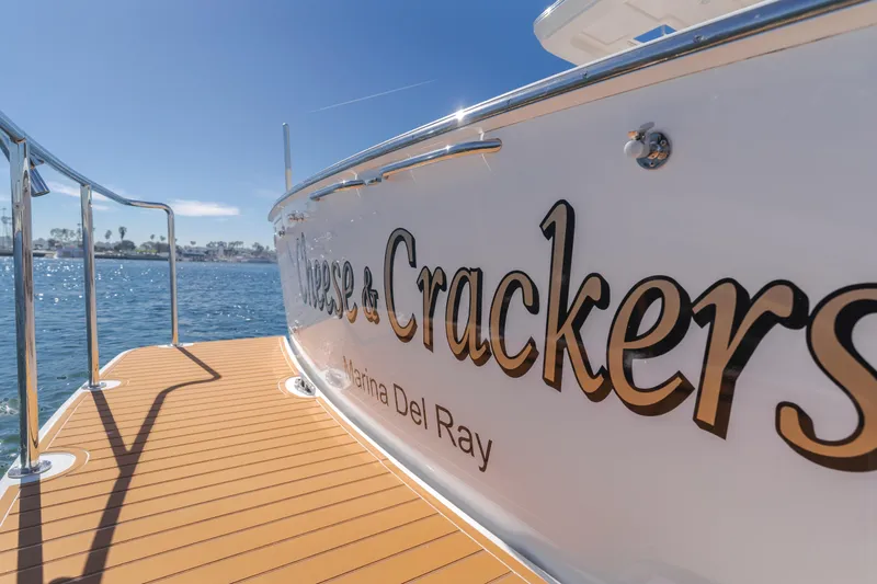 Slide: The Image of 2006 West Bay 64 yacht docked, featuring "Cheese & Crackers" name, sunny marina view. - 39