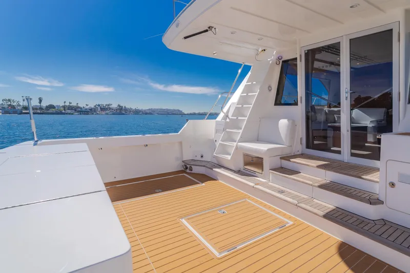 Slide: The Image of Luxurious 2006 West Bay 64 yacht deck with seating, overlooking serene waters. - 40