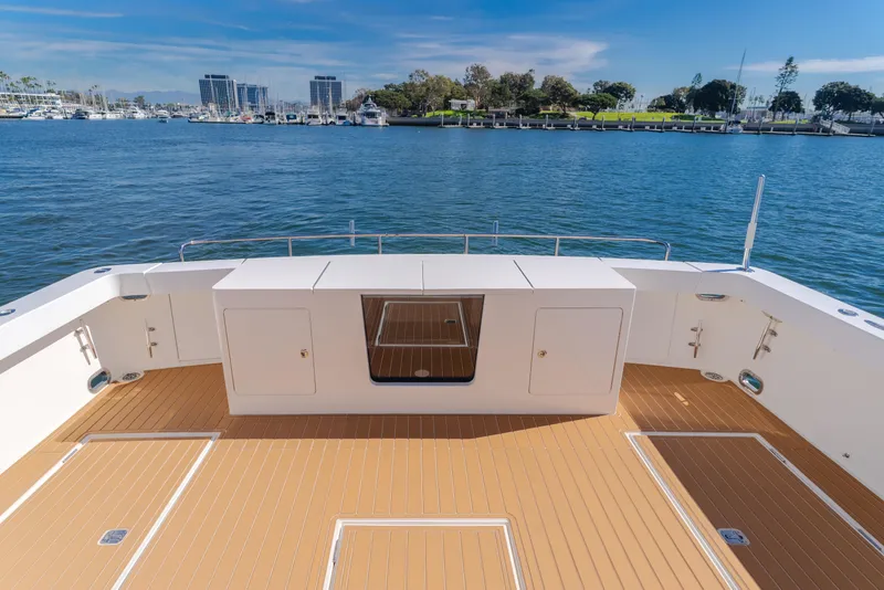 Slide: The Image of 2006 West Bay 64 yacht deck with scenic marina view, featuring sleek design and spacious layout. - 41