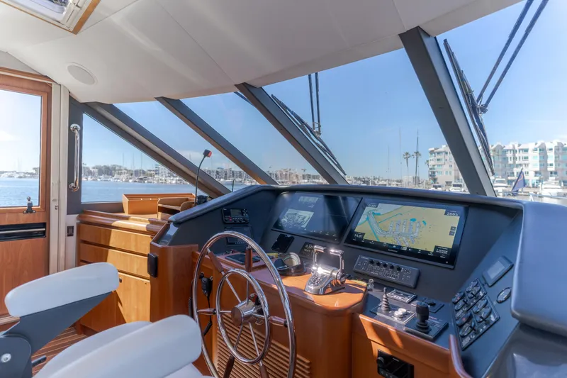 Slide: The Image of Helm of 2006 West Bay 64 yacht with navigation screens and steering wheel. - 53