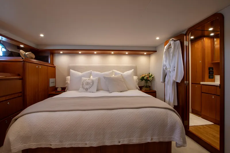 Slide: The Image of Luxurious bedroom interior of 2006 West Bay 64 yacht with elegant wood finishes and cozy bedding. - 63