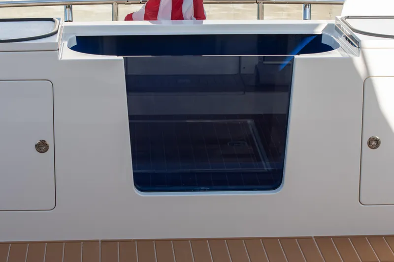 Slide: The Image of 2006 West Bay 64 yacht with sleek white exterior and blue-tinted window detail. - 66