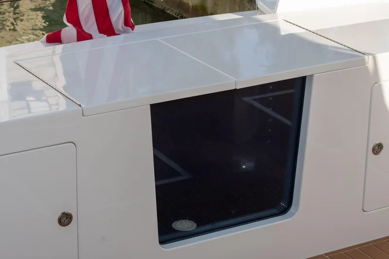 Slide: The Image of 2006 West Bay 64 yacht deck with storage compartment and American flag. - 67