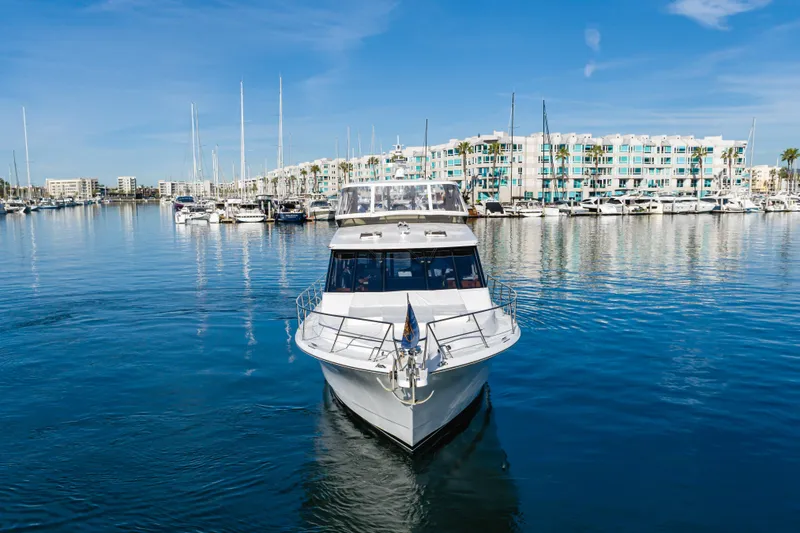 Slide: The Image of 2006 West Bay 64 yacht docked in a marina with modern buildings in the background. - 9