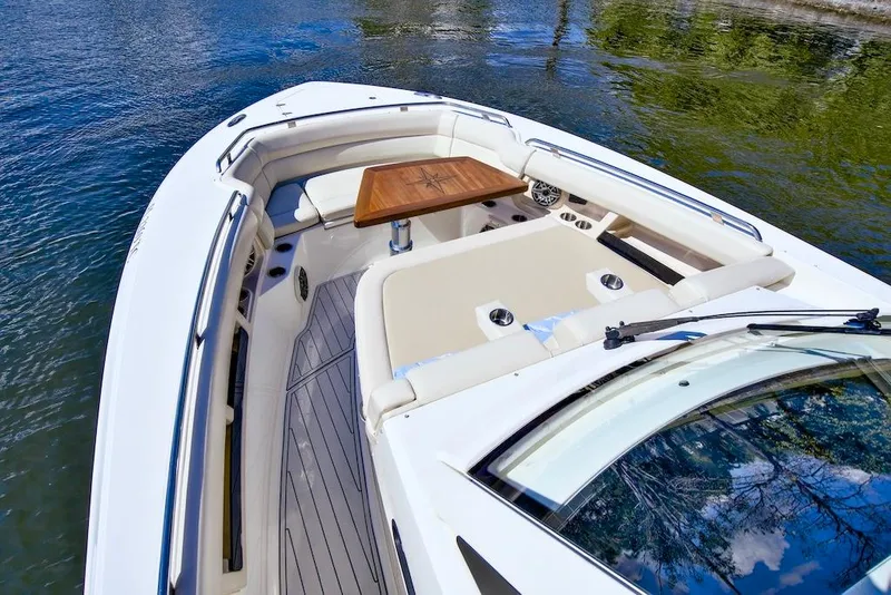 Slide: The Image of 2019 Boston Whaler 350 Realm boat with spacious seating and wooden table on calm water. - 10