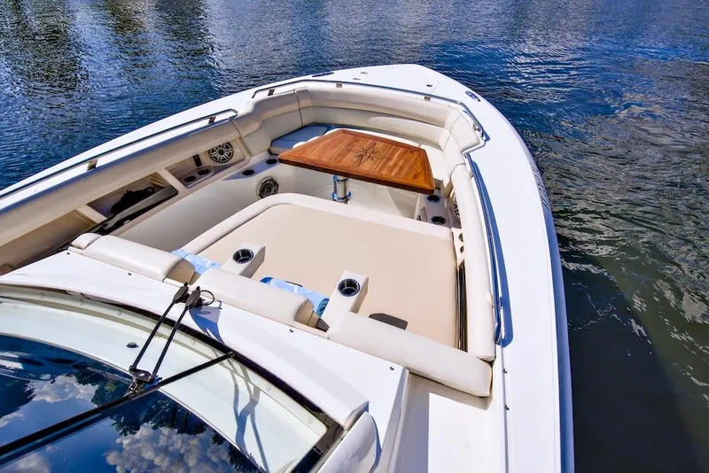 Slide: The Image of 2019 Boston Whaler 350 Realm boat interior with seating and table on water. - 11