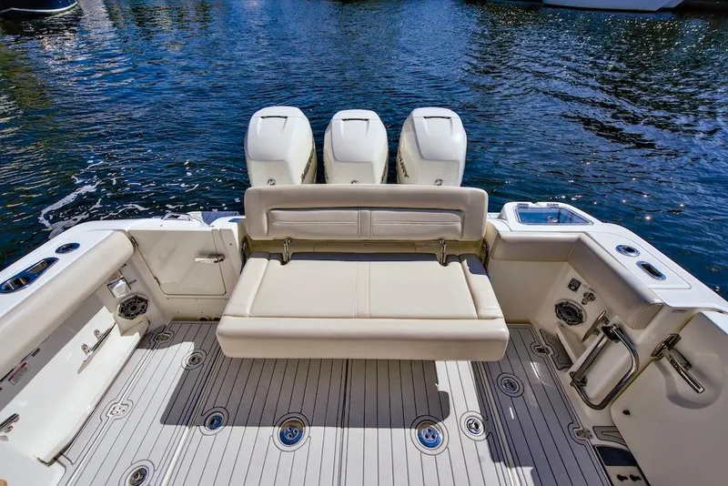 Slide: The Image of 2019 Boston Whaler 350 Realm boat deck with seating and triple outboard engines. - 20