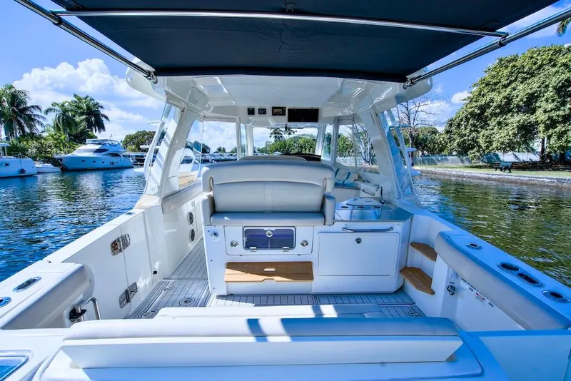 Slide: The Image of 2019 Boston Whaler 350 Realm boat interior with seating, docked on a sunny day. - 23