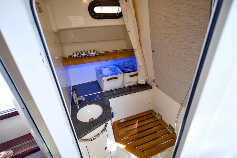 Slide: The Image of Interior of 2019 Boston Whaler 350 Realm, featuring a compact sink and storage area. - 28