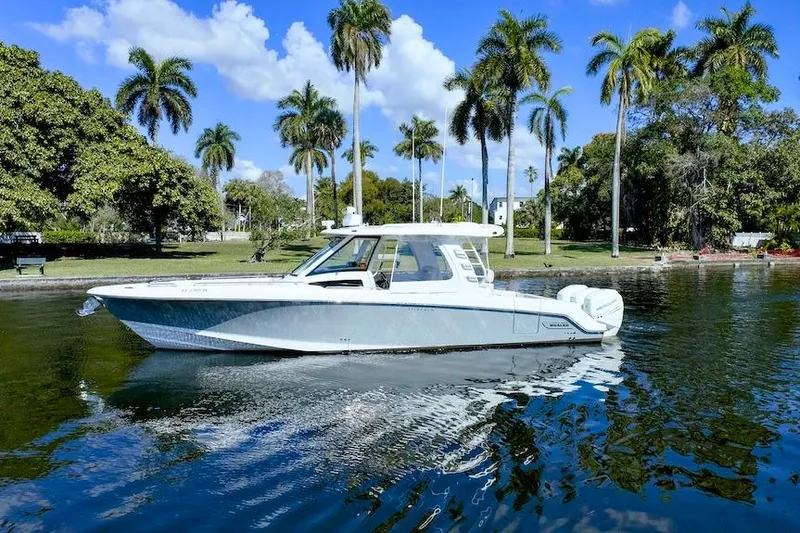 Slide: The Image of 2019 Boston Whaler 350 Realm boat on water with palm trees in background. - 4