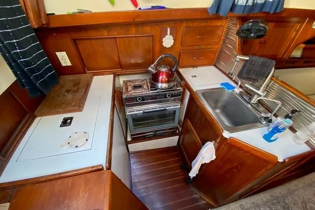 Slide: The Image of 1979 Morgan 321 boat kitchen with stove, sink, and wooden cabinetry. - 11