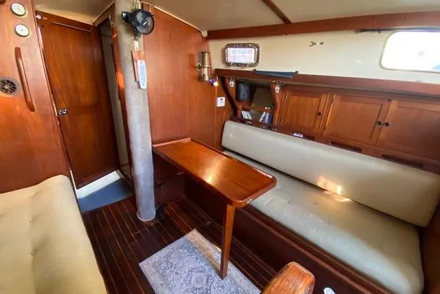 Slide: The Image of 1979 Morgan 321 yacht interior with wooden furnishings and cozy seating area. - 14