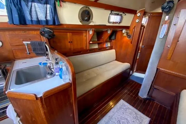Slide: The Image of 1979 Morgan 321 yacht interior with wooden cabinetry, sink, and cushioned seating. - 15