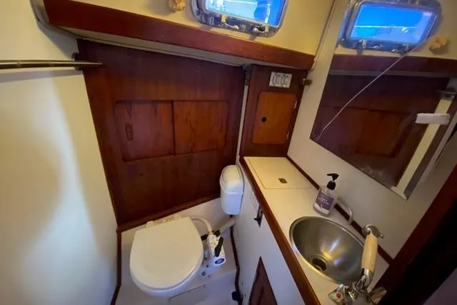 Slide: The Image of 1979 Morgan 321 yacht bathroom with sink, toilet, and wooden cabinetry. - 16