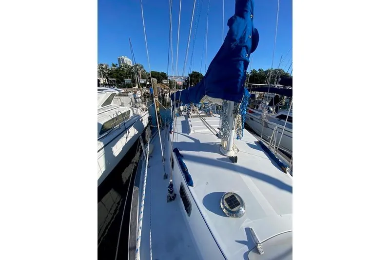 Slide: The Image of 1979 Morgan 321 sailboat docked, featuring blue sail cover and clear sky. - 5