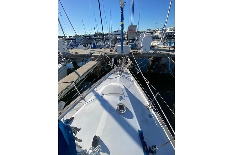 Slide: The Image of 1979 Morgan 321 sailboat docked at marina, clear blue sky, view from bow. - 6