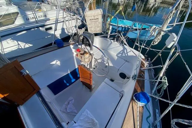 Slide: The Image of 1979 Morgan 321 sailboat cockpit with steering wheel and nautical equipment. - 8