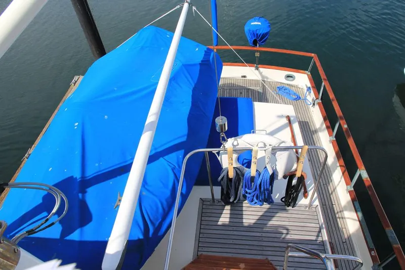 Slide: The Image of 1974 Grand Banks 42 Motoryacht deck with blue cover and nautical equipment. - 10