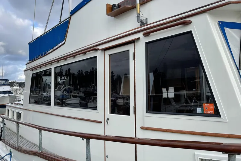 Slide: The Image of 1974 Grand Banks 42 Motoryacht with wooden railings and large windows at a marina. - 11