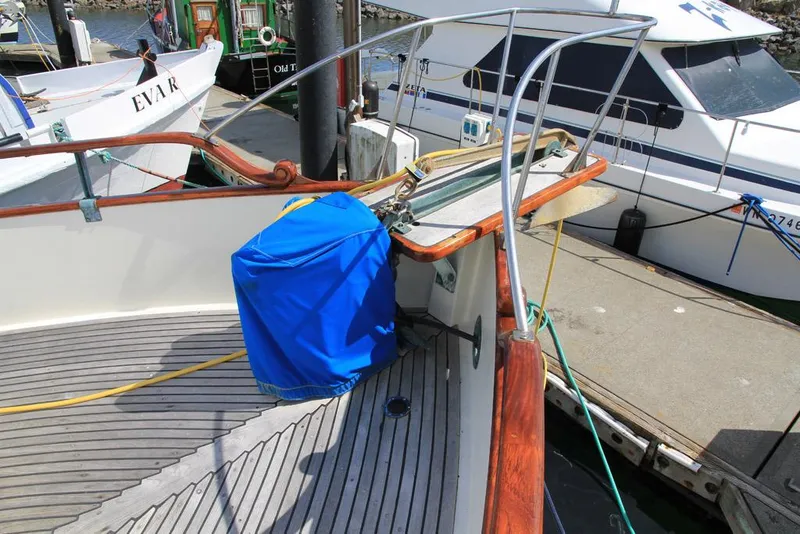 Slide: The Image of 1974 Grand Banks 42 Motoryacht deck with blue cover and docked boats. - 12