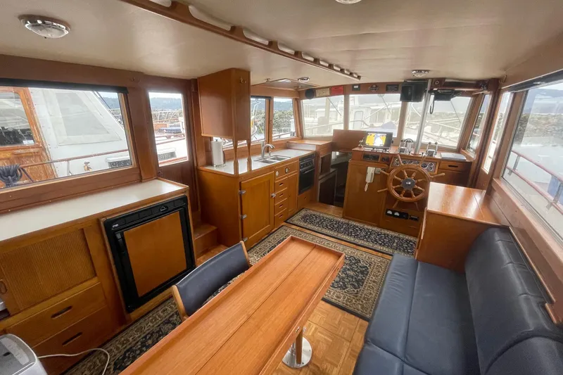 Slide: The Image of 1974 Grand Banks 42 Motoryacht interior with wooden helm, seating, and kitchenette. - 19