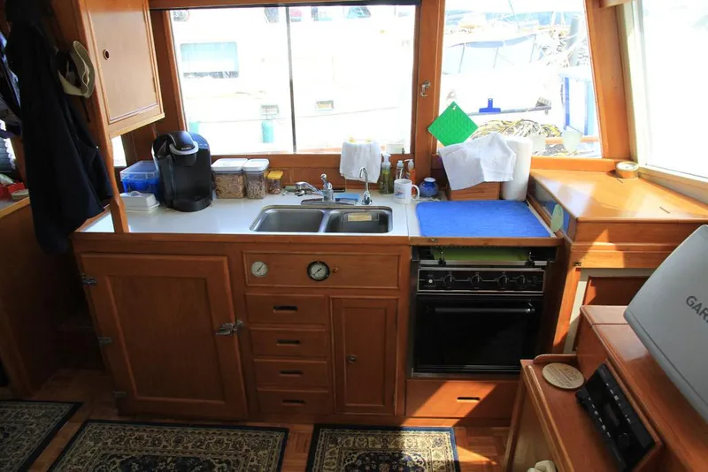Slide: The Image of 1974 Grand Banks 42 Motoryacht kitchen with wooden cabinetry, sink, and appliances. - 22