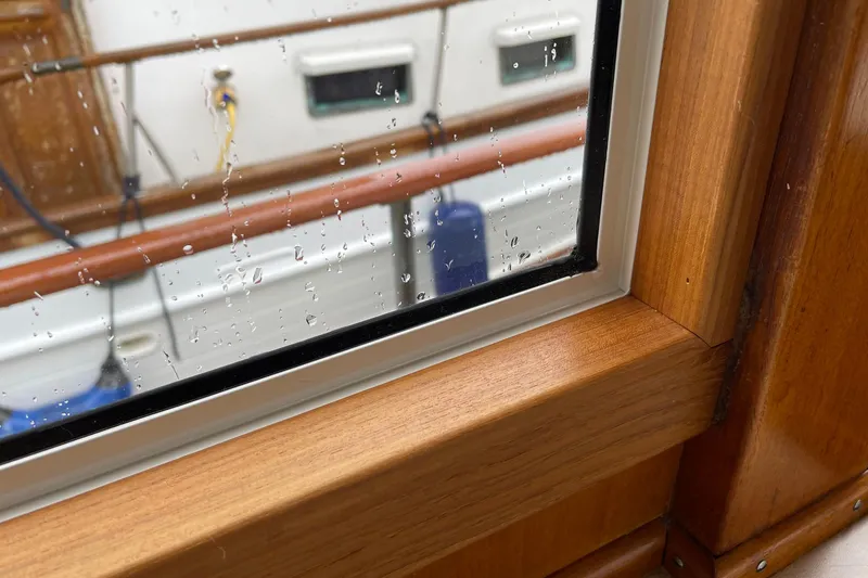Slide: The Image of Raindrops on window of 1974 Grand Banks 42 Motoryacht, showcasing wooden interior. - 25
