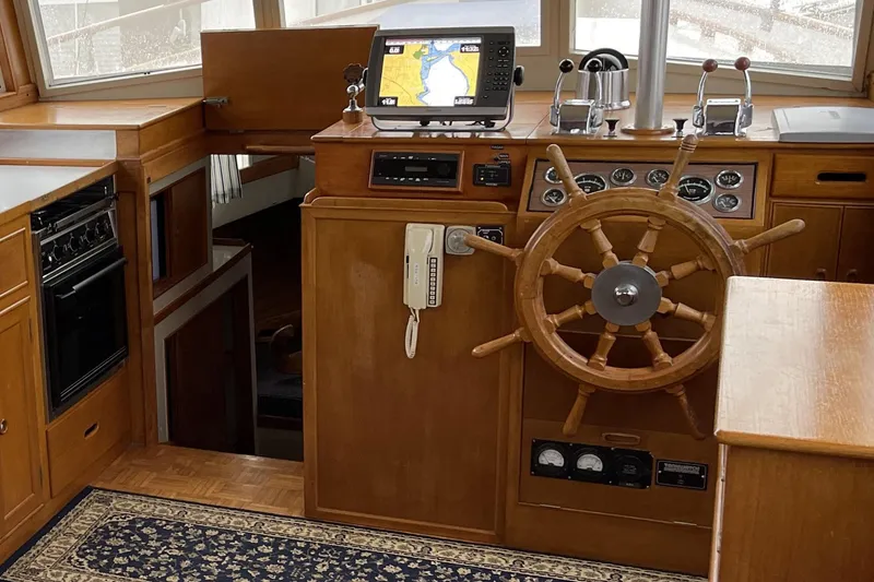 Slide: The Image of 1974 Grand Banks 42 Motoryacht helm with wooden wheel, navigation equipment, and classic interior design. - 27