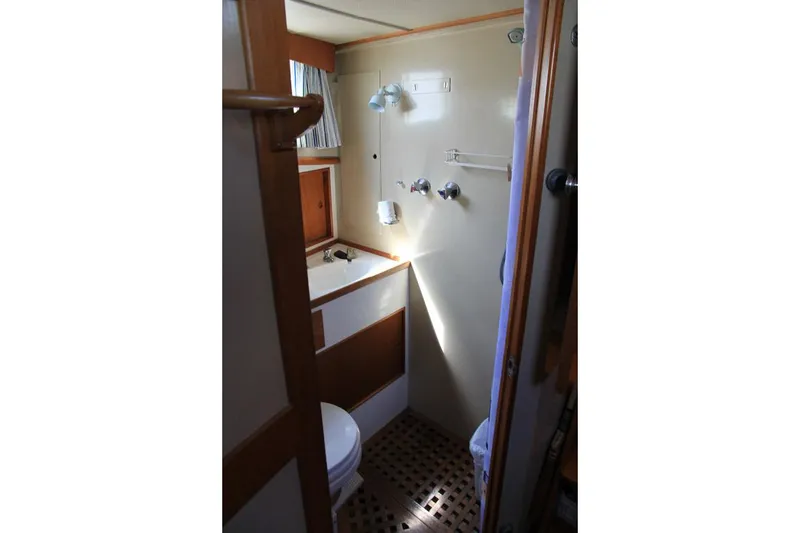 Slide: The Image of 1974 Grand Banks 42 Motoryacht bathroom with sink, toilet, and wooden accents. - 28