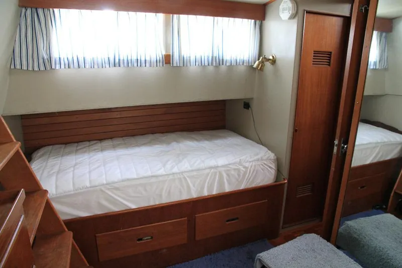 Slide: The Image of 1974 Grand Banks 42 Motoryacht cabin with wooden interior and single bed. - 30