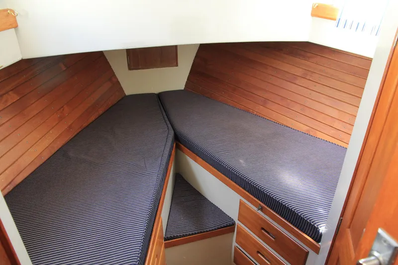 Slide: The Image of 1974 Grand Banks 42 Motoryacht cabin with twin beds and wooden paneling. - 35