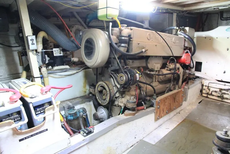 Slide: The Image of Engine room of a 1974 Grand Banks 42 Motoryacht, showcasing mechanical components and batteries. - 36