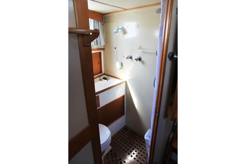 Slide: The Image of 1974 Grand Banks 42 Motoryacht bathroom with wooden accents and compact design. - 37