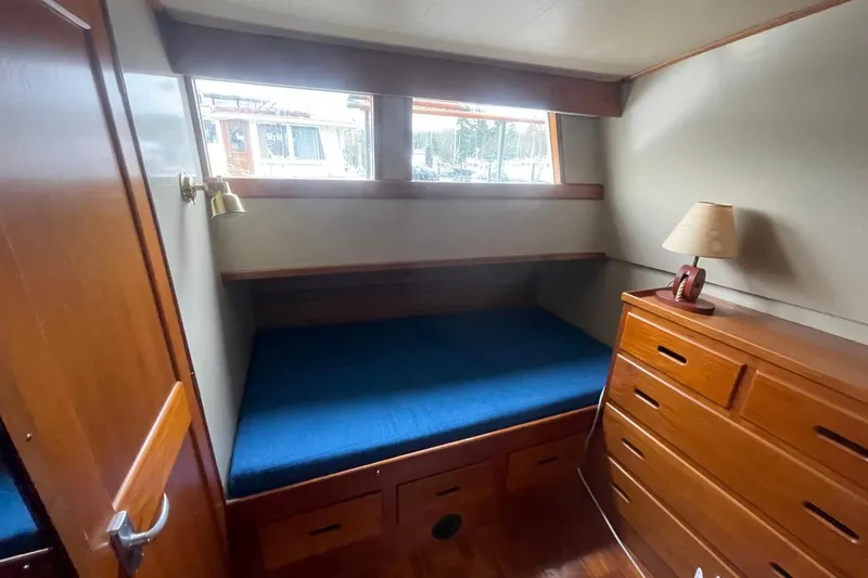 Slide: The Image of Cozy cabin interior of 1974 Grand Banks 42 Motoryacht with wooden furniture and blue bedding. - 41