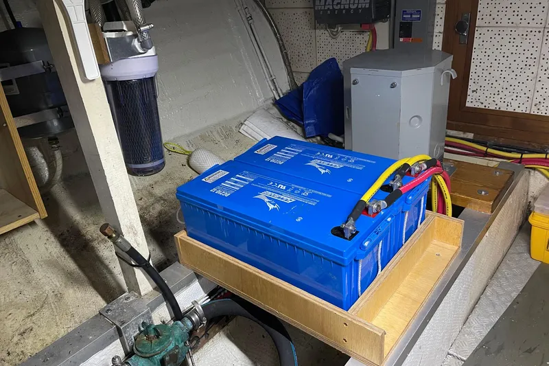 Slide: The Image of Battery setup in 1974 Grand Banks 42 Motoryacht engine room, featuring blue marine batteries. - 44