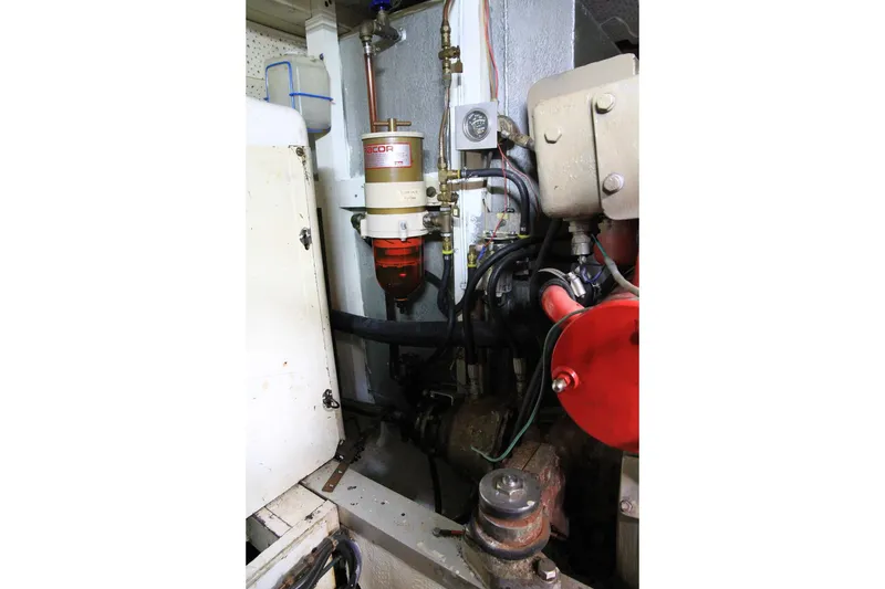 Slide: The Image of Engine room of 1974 Grand Banks 42 Motoryacht, showcasing mechanical components and fuel filter. - 47