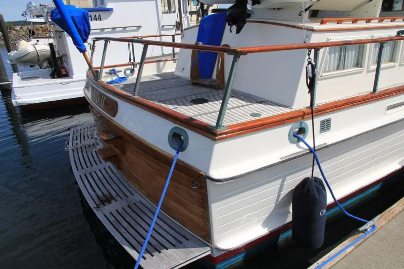 Slide: The Image of 1974 Grand Banks 42 Motoryacht docked, showcasing classic wooden design and nautical features. - 6