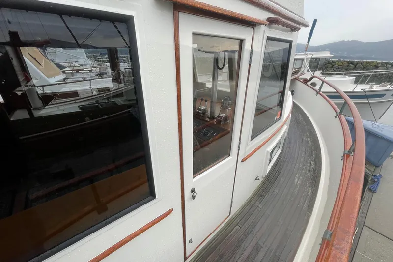 Slide: The Image of 1974 Grand Banks 42 Motoryacht with wooden deck and windows, docked at marina. - 9