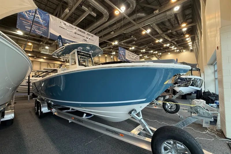 The Image of 2026 Cobia 285 Center Console boat displayed indoors on a trailer. - 0