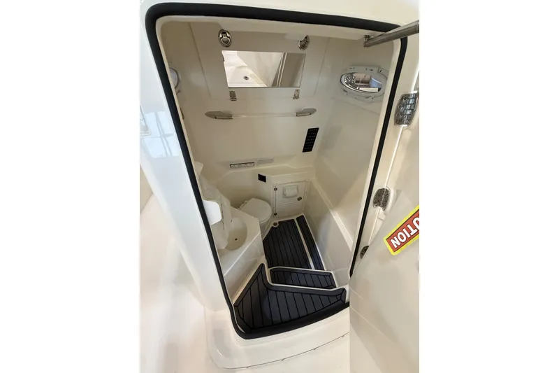 Slide: The Image of 2026 Cobia 285 Center Console boat interior with compact restroom and modern amenities. - 16
